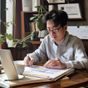 探花论坛内容总监陈夏的工作照，正在专注审阅内容文档，桌上摆有咖啡杯与笔记本，展现专业认真的工作状态